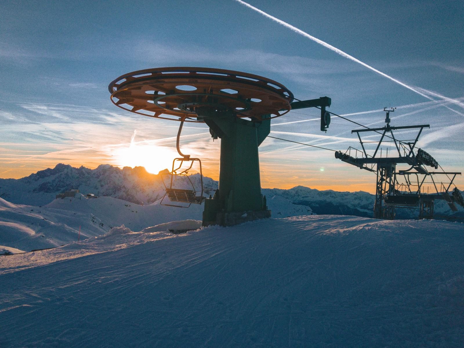 Stoeltjeslift in de sneeuw bij zonsondergang